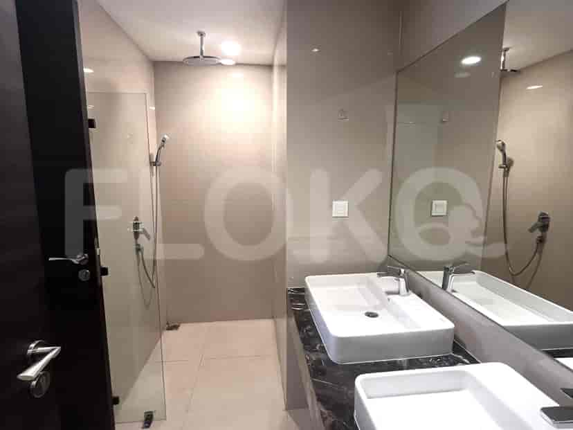 Kamar mandi yang bersih dengan pancuran hujan dan wastafel modern.