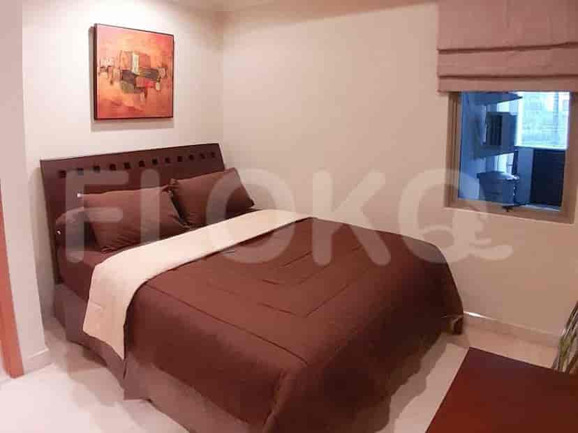 A bedroom with a bed and a painting on the wall.