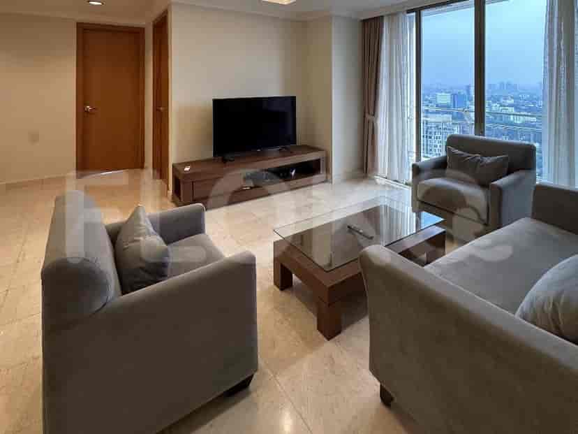 Living room with a grey sofa, TV, and city views.