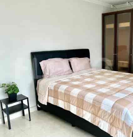 Cozy bedroom featuring a bed with soft bedding, a side table, and a small plant.