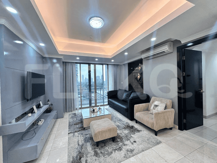 A modern living room with a grey sofa, TV, and city view.