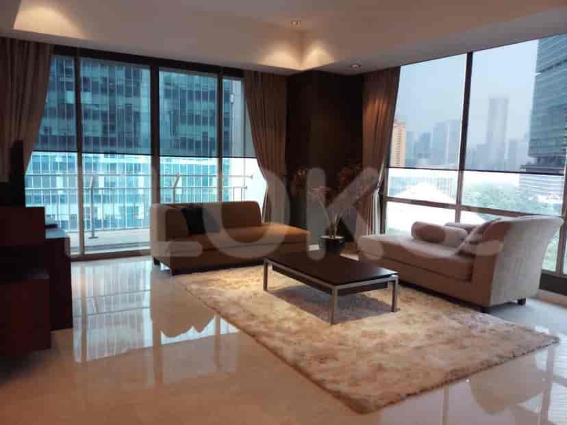 Spacious living room with modern furniture, large windows, and a city view.