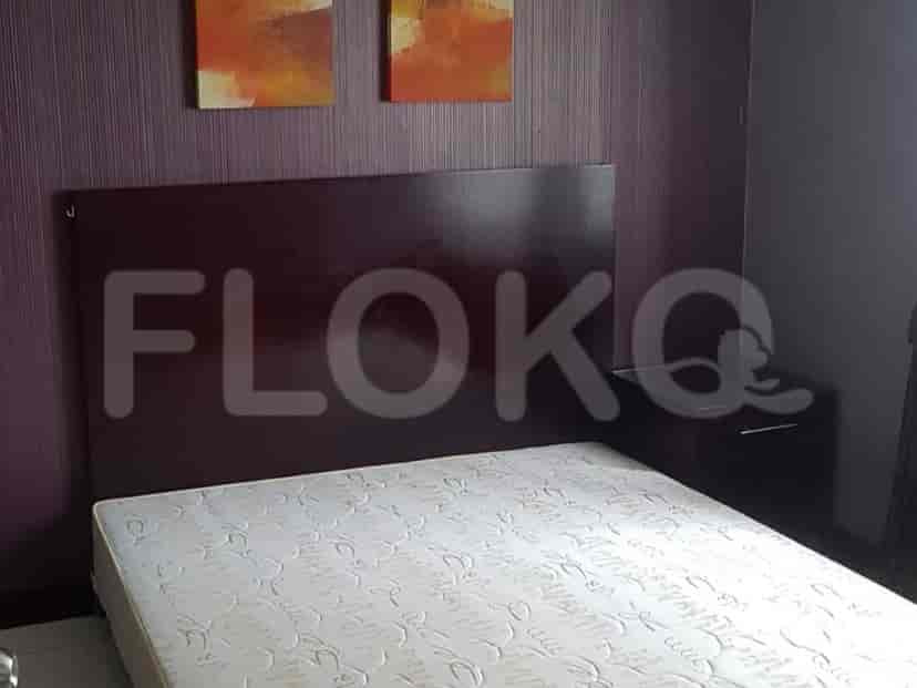 Kamar tidur dengan tempat tidur, meja samping tempat tidur, dan beberapa karya seni.