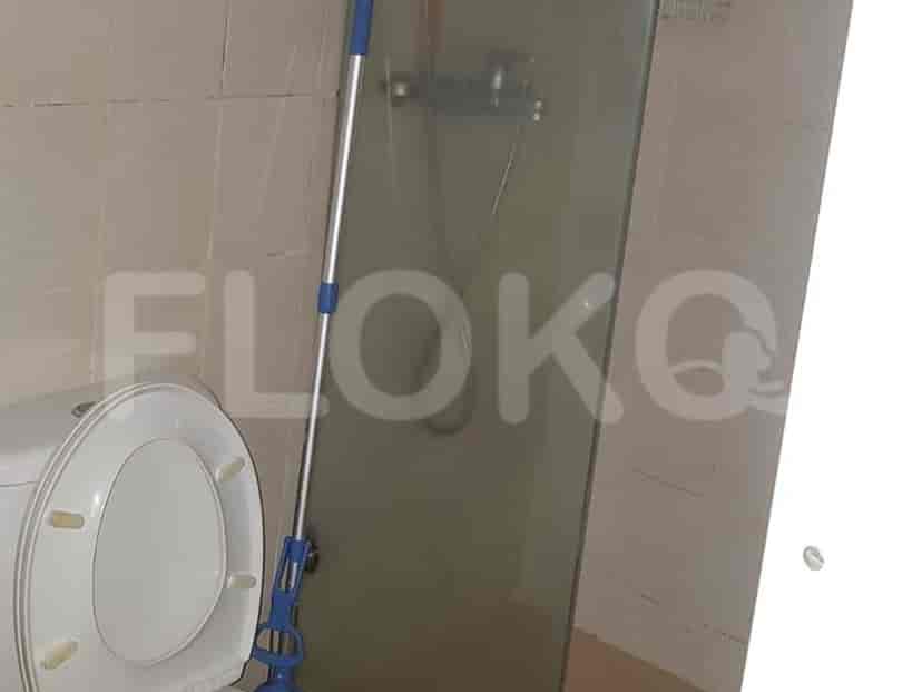 Kamar mandi dengan toilet dan area pancuran.