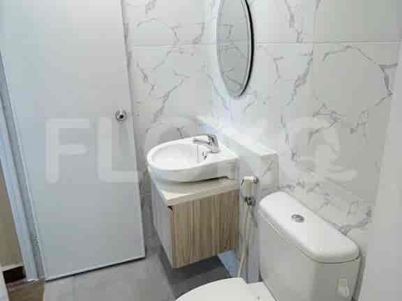 A modern bathroom with a white sink and marble tiles.