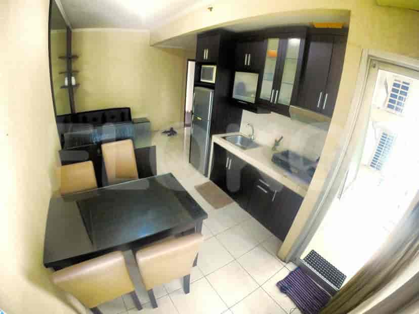 The dining area, kitchen, and sofa are visible, providing a view of the apartment's layout.
