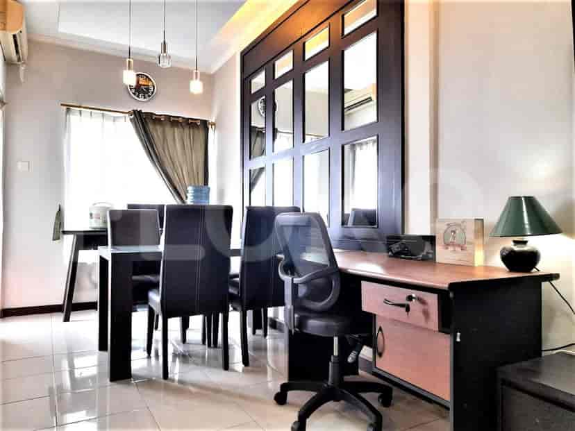 Area makan dengan meja kayu gelap, kursi hitam, dan area meja.
