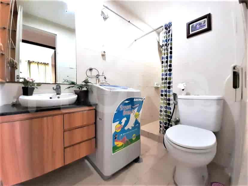 Kamar mandi dengan wastafel, mesin cuci, dan shower.