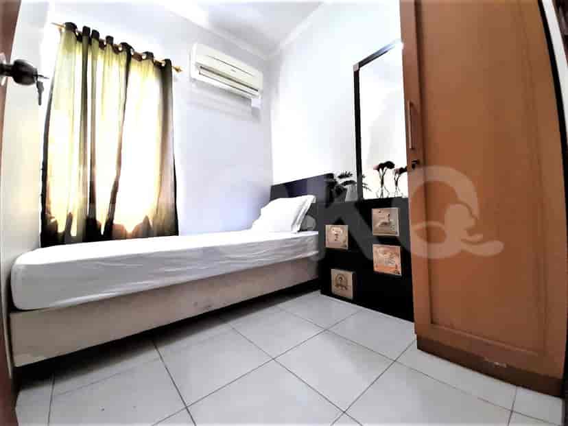 Kamar tidur dengan tempat tidur tunggal dan cermin.