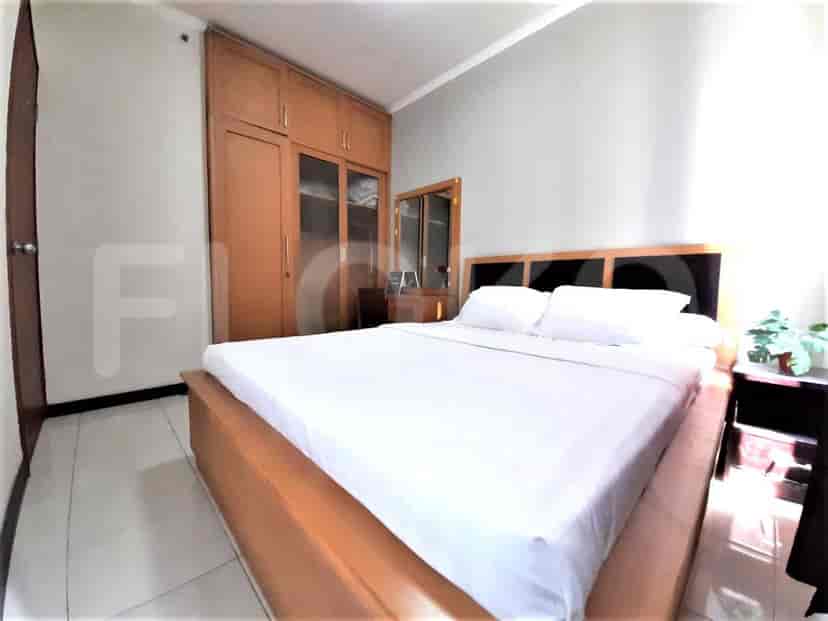 Kamar tidur utama dengan tempat tidur ganda dan lemari besar.