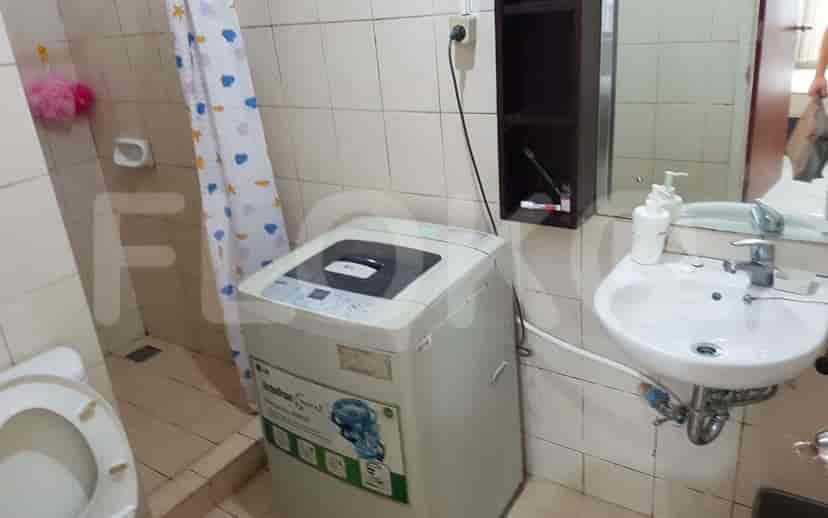 Bathroom with a washing machine, sink, and shower.