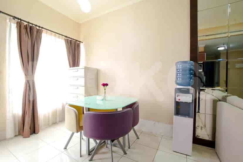 Dining area with a round glass table and chairs, and a water dispenser.