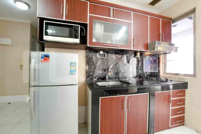 A well-equipped kitchen with wooden cabinets, a microwave, and a refrigerator.