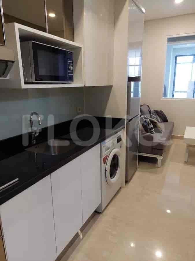 Open kitchen with a washing machine, sink and microwave.