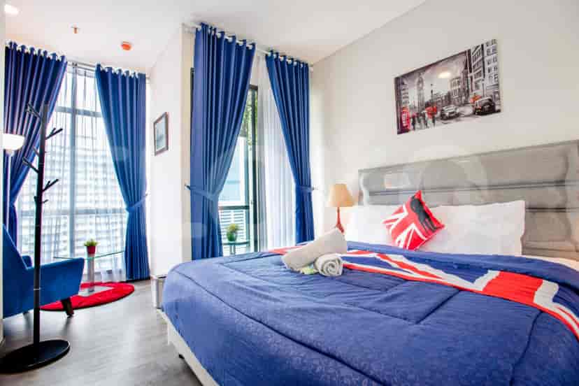 A well-lit bedroom with a large bed, blue bedding, and British-themed accents.