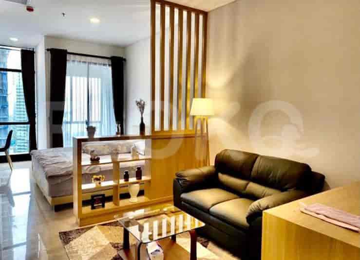 Bedroom area with a bed, wooden divider, and access to living area.