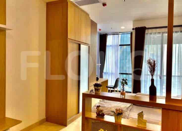 Bedroom area with a bed, wooden divider, and access to living area.