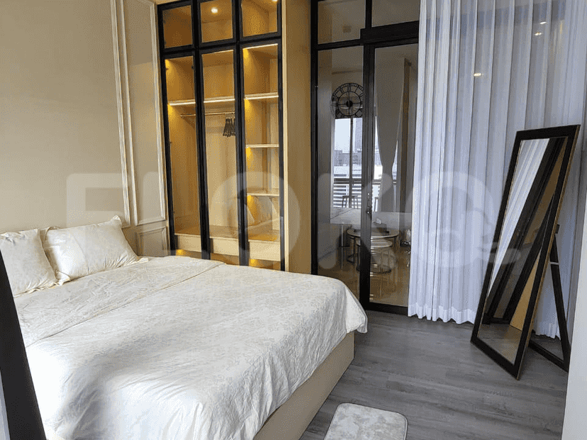 A bedroom with a bed, a closet, and a mirror.