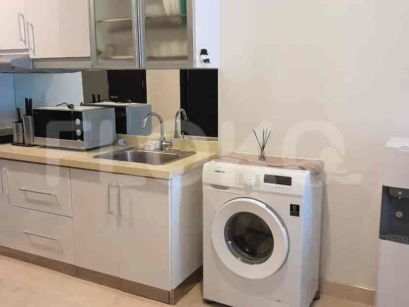 A modern kitchen with white cabinets and a washing machine.