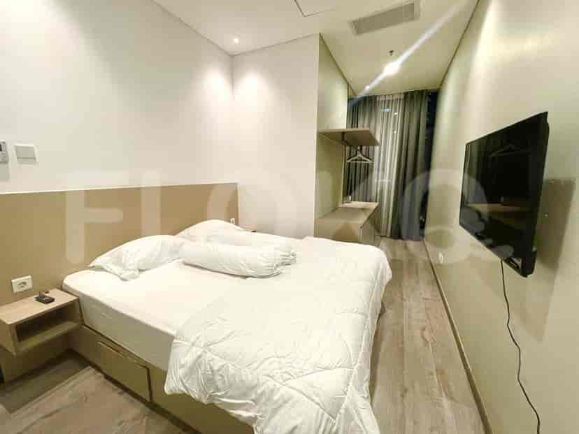 Master bedroom with a bed, bedside table, and a wall-mounted TV.