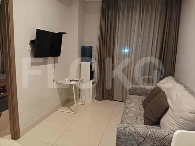 A compact living space with a TV, sofa, and water dispenser.