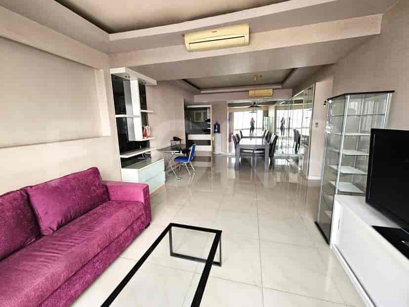 Spacious living room with a purple sofa, glass coffee table, and dining area.