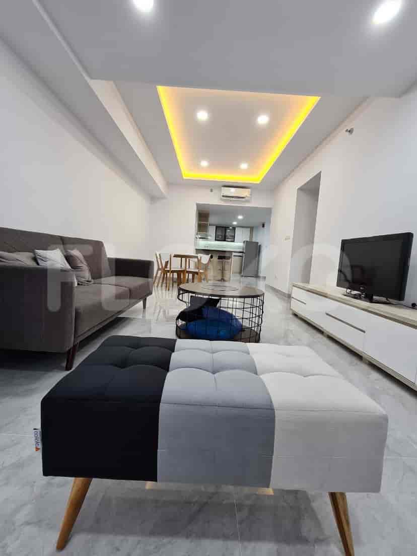 Ruang tamu yang menampilkan bangku kaki color block dan pemandangan ke dapur.