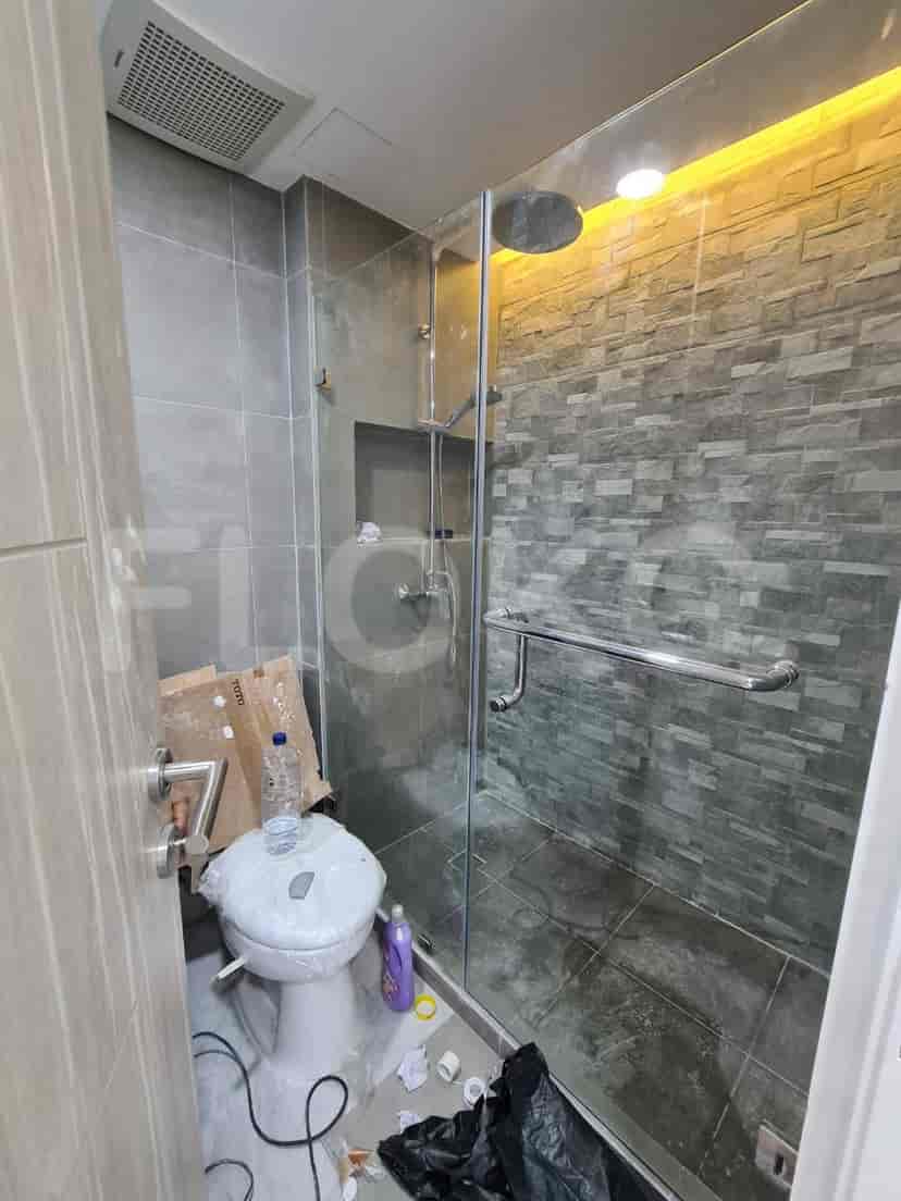 Kamar mandi modern dengan kotak pancuran kaca.