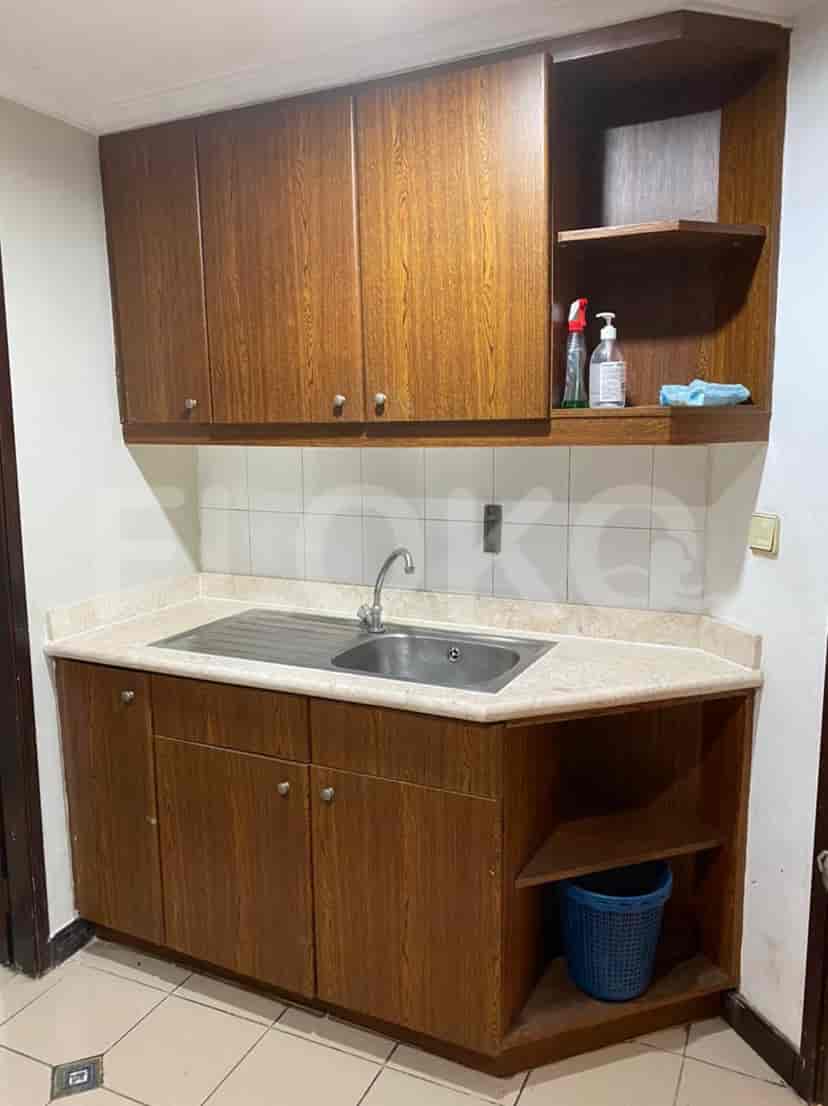 A compact kitchen with wooden cabinets, a sink, and countertop space.