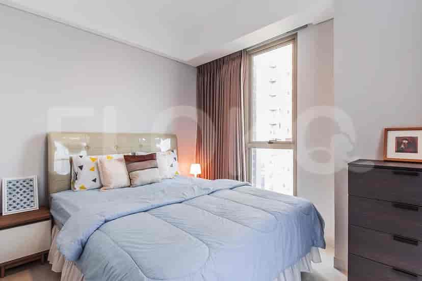 Kamar tidur yang terang dengan tempat tidur ukuran queen, meja samping tempat tidur, dan jendela besar dengan gorden.