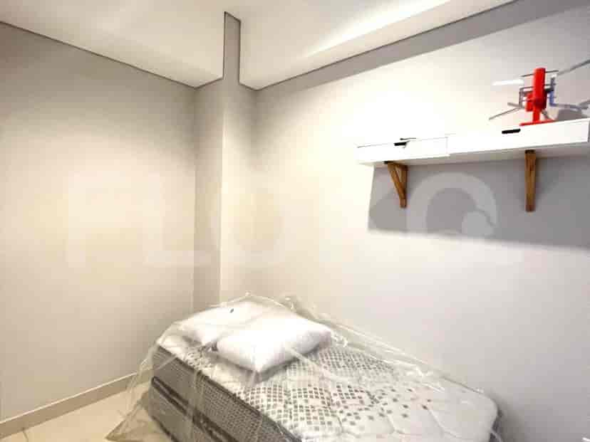 A minimalist bedroom with a single bed, clean white walls, and wooden accents.