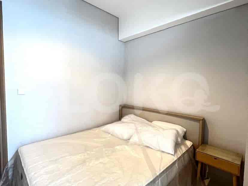 A bedroom featuring a double bed, nightstand, and simple decor.