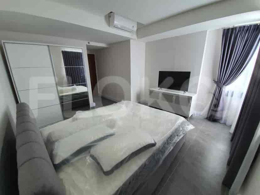 Bedroom with a bed, built-in wardrobe, and a wall-mounted TV.