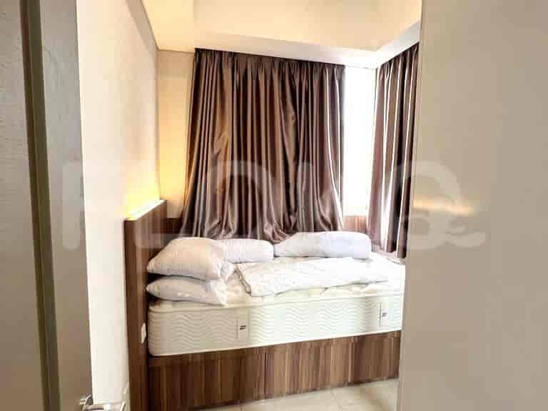 A cozy bedroom with a single bed, brown curtains, and a simple decor.