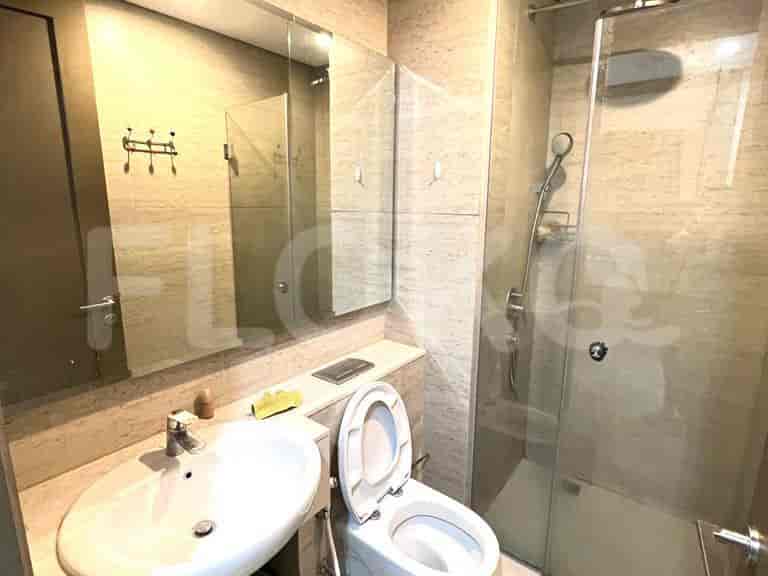 A modern bathroom, featuring a vanity with a mirror, toilet, and a glass-enclosed shower.
