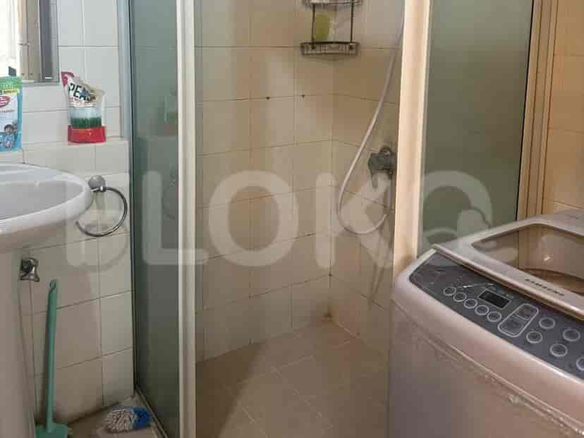 A bathroom with a shower and a washing machine.