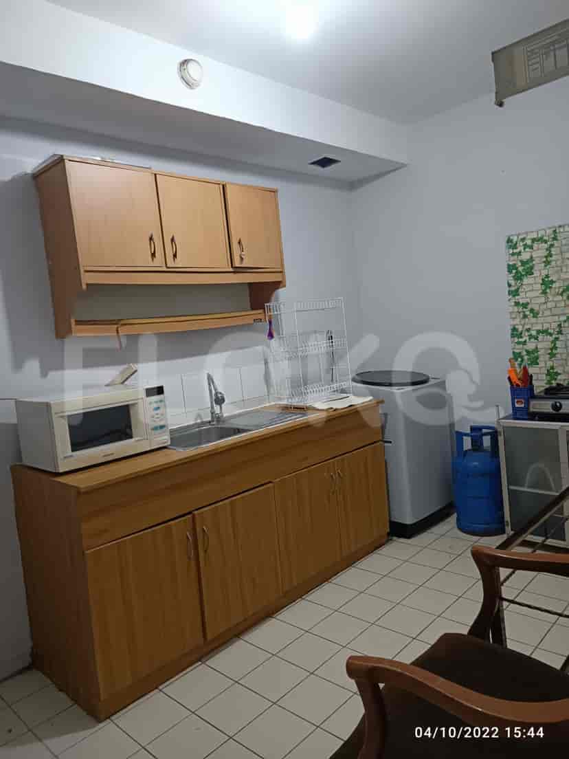 Kitchen with wooden cabinets, a sink, microwave, and washing machine.