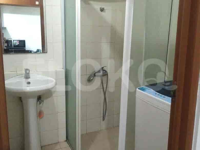 A simple bathroom with a shower area and a washing machine.