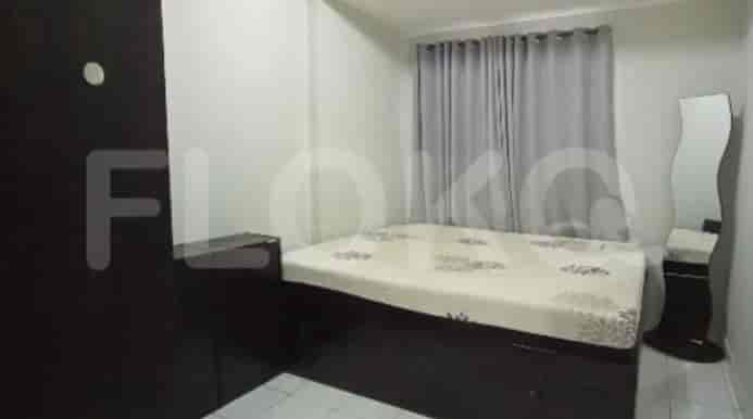 A bedroom with a bed, wardrobe, and a full-length mirror.
