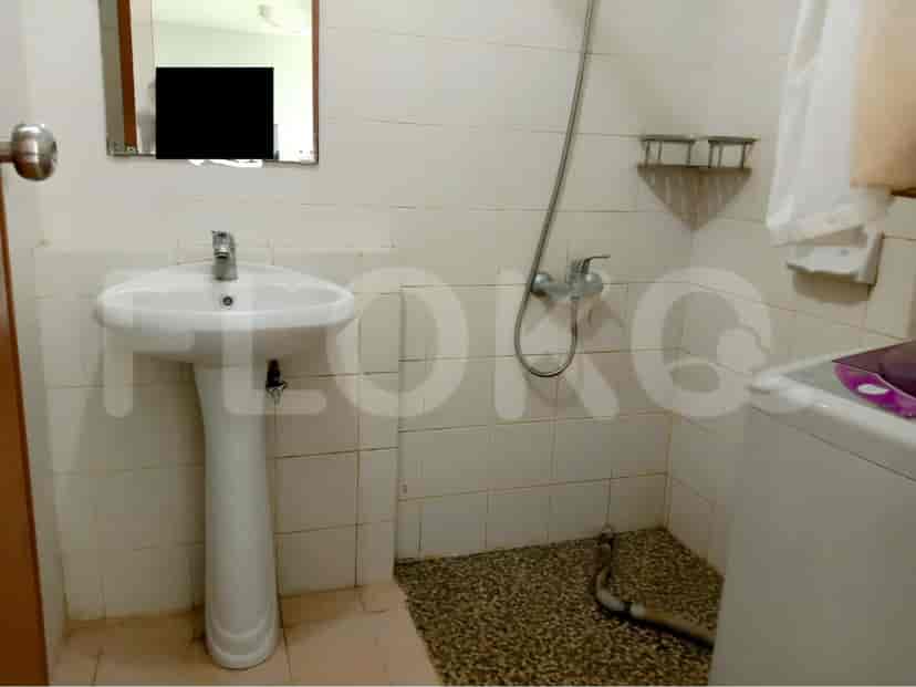 Small bathroom with sink, shower, and washing machine.