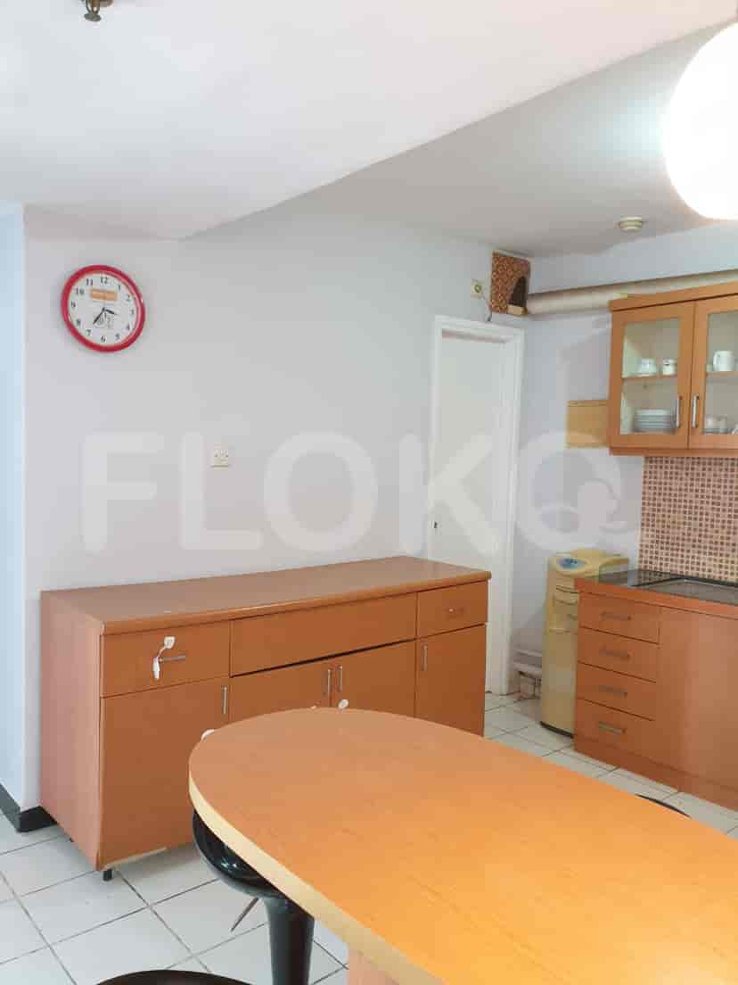 A well-equipped kitchen with wooden cabinets, a clock, and a breakfast bar.
