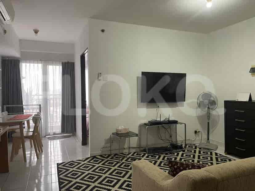 Living room with a TV, fan, and black and white rug.
