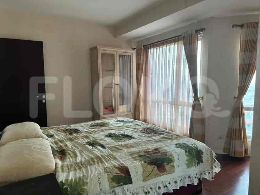 Kamar tidur dengan tempat tidur, lemari, dan jendela dengan gorden.