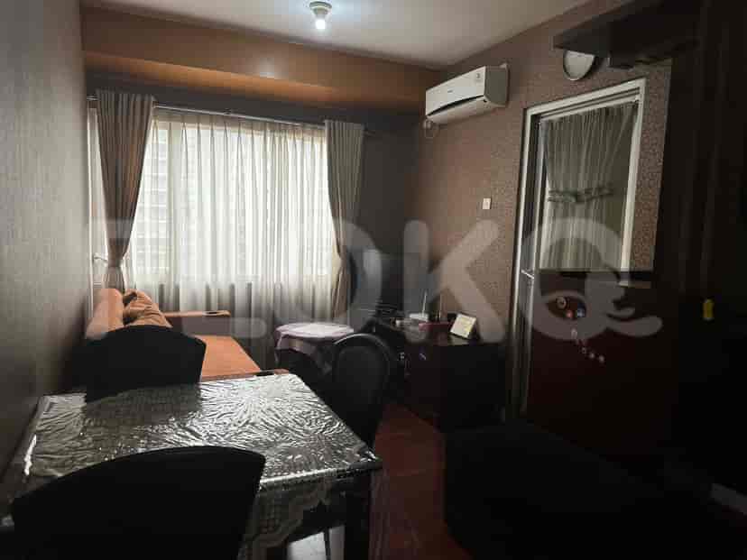 Ruang tamu dan dapur dengan meja makan, sofa, dan TV