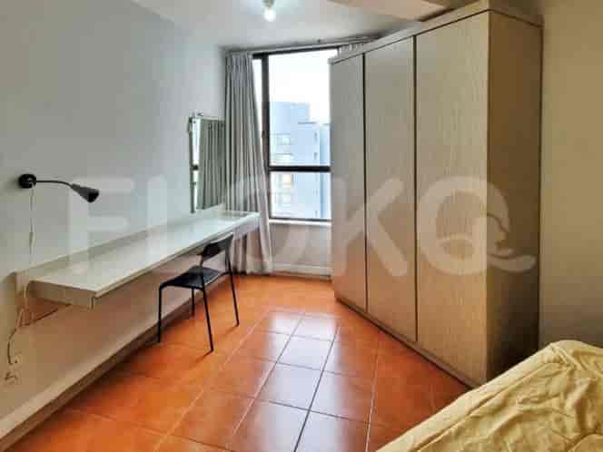 A small bedroom with a single bed, desk, chair, and wardrobe.