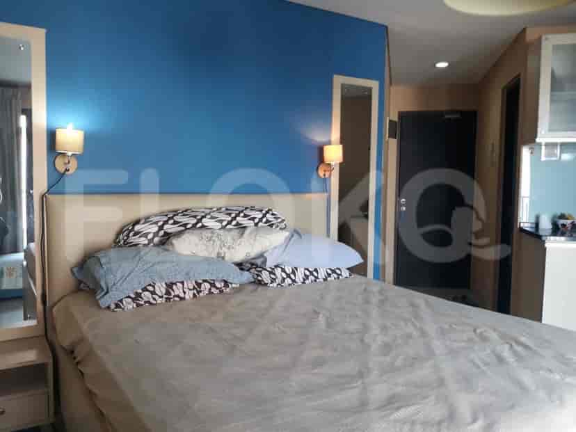 Bedroom with a bed, side table with a mirror, and a door leading to a bathroom.