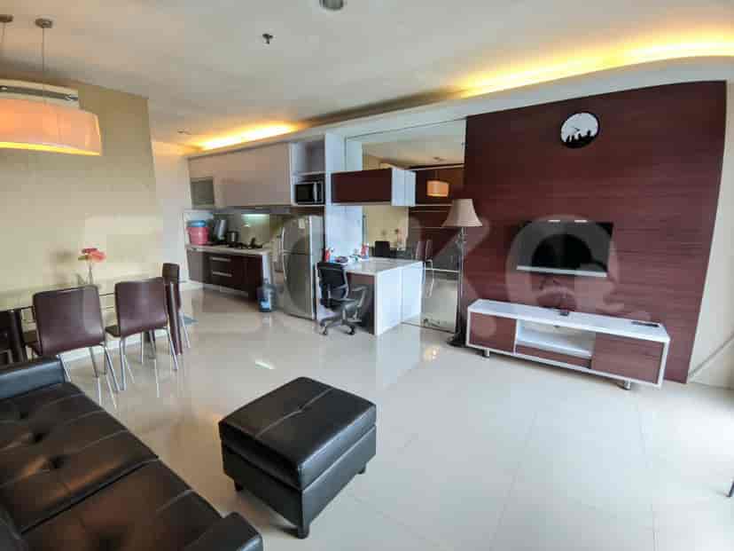 A modern apartment with a living room, dining area, and open kitchen. Features include a black sofa, a glass dining table, a well-equipped kitchen with stainless steel appliances, and a built-in TV cabinet.