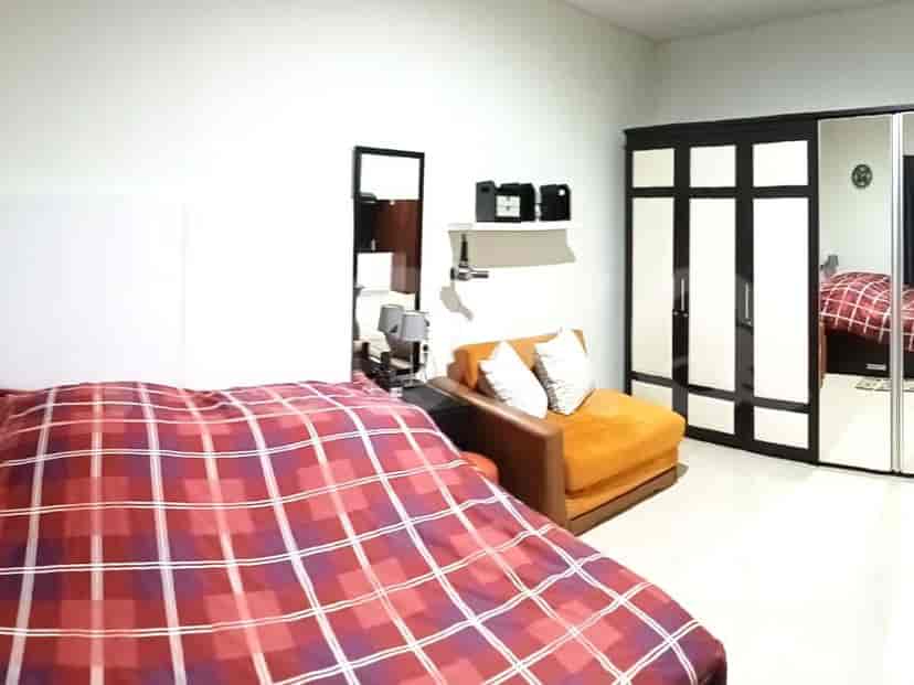 A spacious bedroom with a large bed, wardrobe, and seating area.