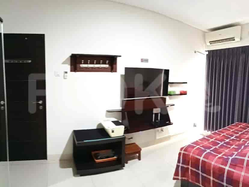 Another view of the bedroom with bed, wardrobe and wall-mounted TV.