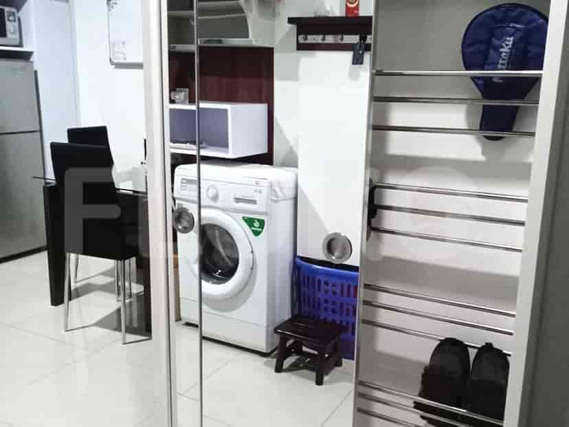 A combined laundry and dining area, with a washing machine, dining table, and microwave.